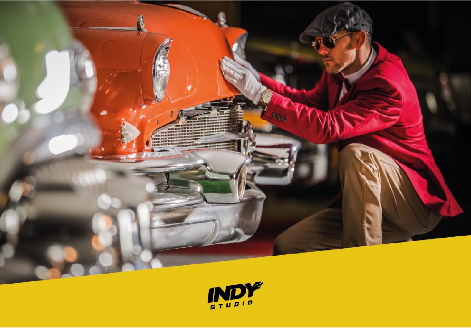 Foto de um homem de boina e luvas brancas ajustando o capô de um carro clássico laranja brilhante. Embaixo, uma faixa amarela com o logotipo Indy Studio.